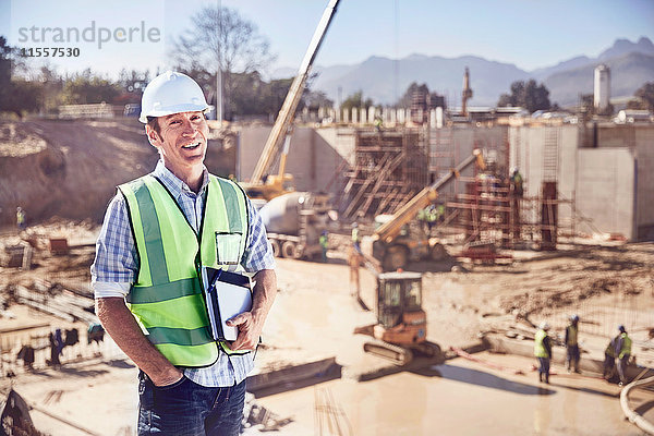 Porträt eines selbstbewussten Bauleiters auf einer sonnigen Baustelle