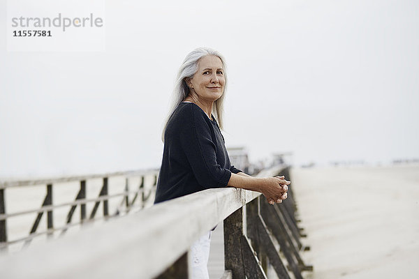 Porträt selbstbewusste Seniorin am Strandpromenadengeländer
