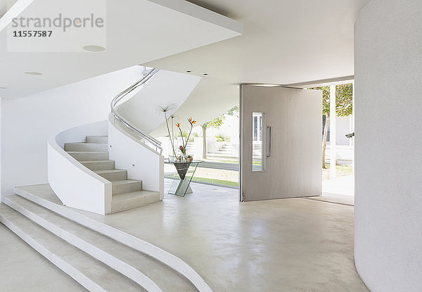 Weißes Foyer und Wendeltreppe in einem modernen  luxuriösen Musterhaus
