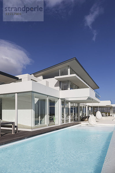 Sonniges  ruhiges  modernes  luxuriöses Haus mit Swimmingpool unter blauem Himmel.