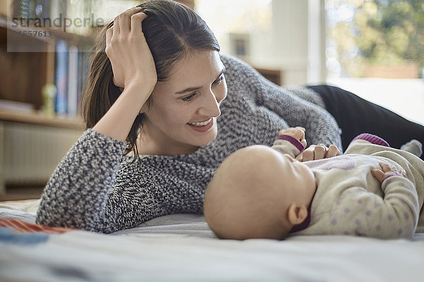 Lächelnde Mutter schaut auf die kleine Tochter