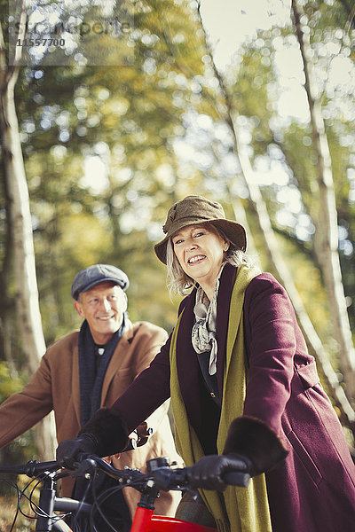 Portrait lächelndes Seniorenpaar Radfahren im Herbstpark