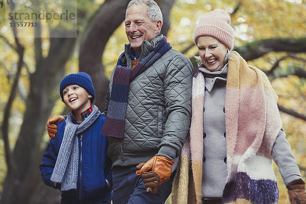 Großeltern zu Fuß mit Enkel im Herbstpark