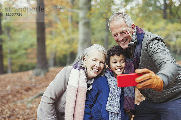 Großeltern und Enkel nehmen Selfie in den Herbstwäldern
