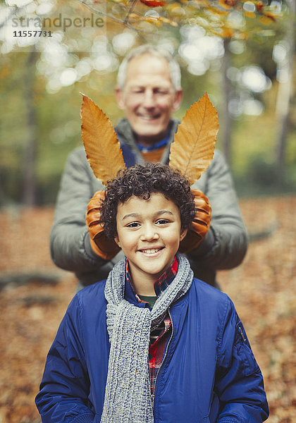 Großvater mit Herbstblättern im Wald