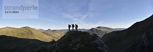 UK  Nordwales  Snowdonia  Nantlle Ridge  Silhouette von drei Bergsteigern