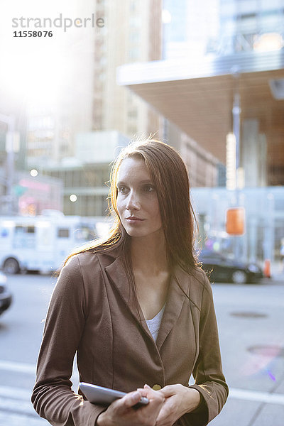 USA  New York  Manhattan  Portrait einer ernsthaften jungen Geschäftsfrau mit Tablette