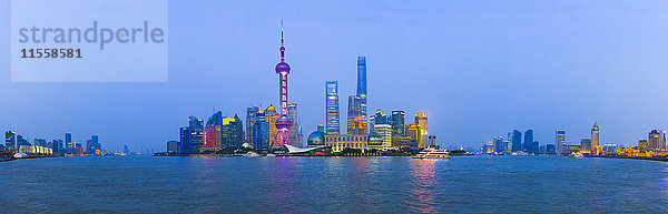 China  Shanghai  Panoramablick auf die Pudong-Skyline mit Huangpu-Fluss im Vordergrund bei Dämmerung