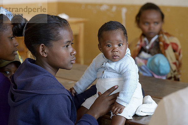 Madagaskar  Fianarantsoa  Junge Mutter mit Baby Junge  die Mutter und Kindergruppe besucht.