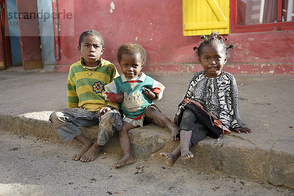 Madagaskar  Fianarantsoa  Obdachlose Kinder auf dem Bürgersteig sitzend