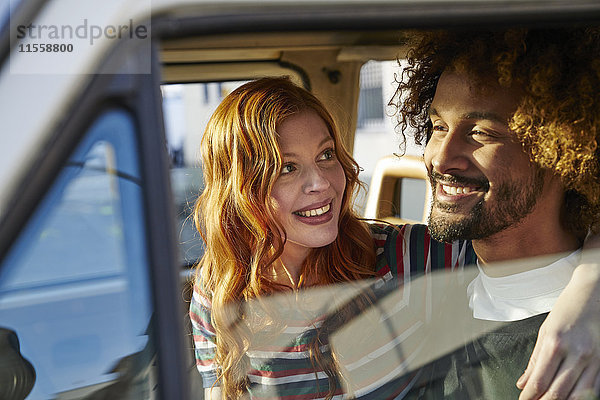 Lächelnde junge Frau schaut Freund im Auto an