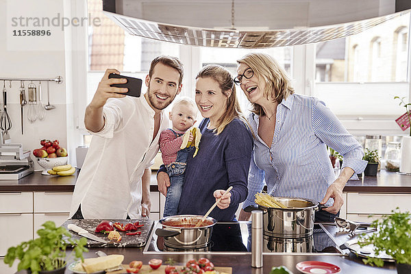 Fröhliches Familienkochen in der Küche mit einem Selfie