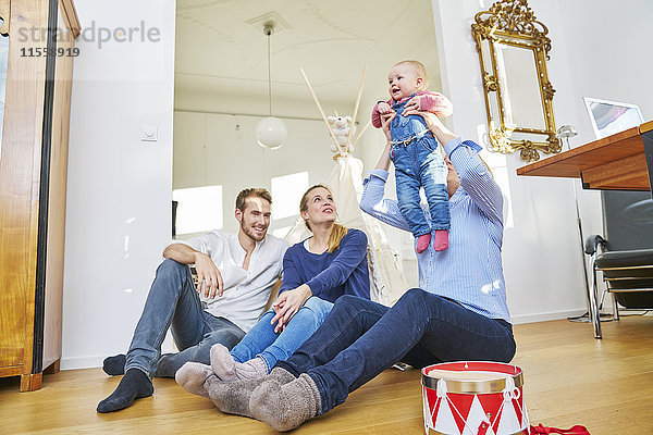 Glückliche Familie mit einem kleinen Mädchen im Wohnzimmer