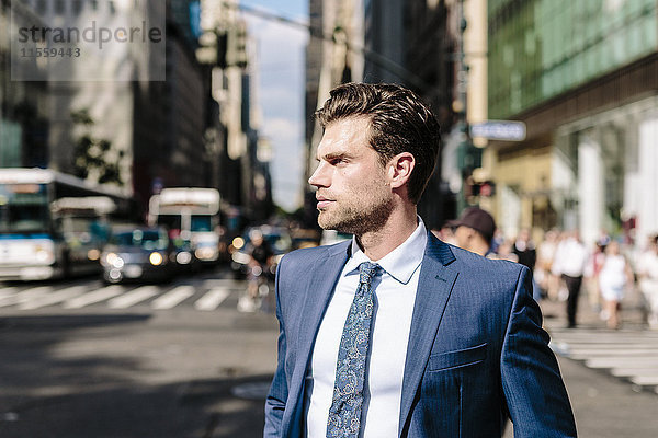 Ein hübscher Geschäftsmann  der in Manhattan spazieren geht.