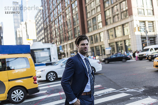 Geschäftsmann in den Straßen von Manhattan mit gelbem Taxi im Hintergrund