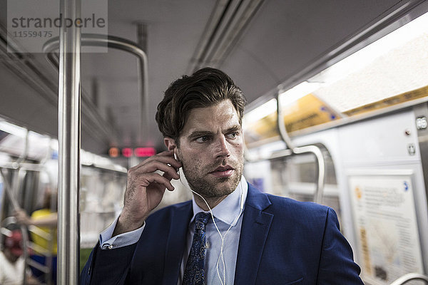 Geschäftsmann in der U-Bahn mit Smartphone