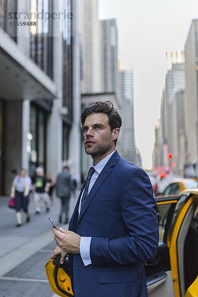 Geschäftsmann verlässt gelbes Taxi in Manhattan