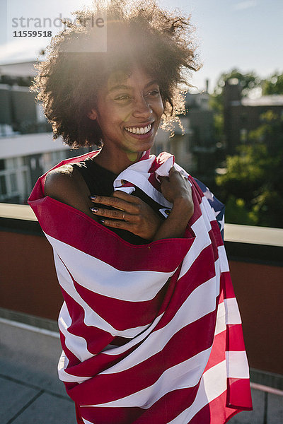 Junge Frau  die auf dem Dach steht  in US-amerikanischer Flagge gewarnt