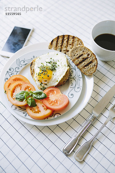 Frühstück mit Eiern  Avocados  Kaffee und Tomaten