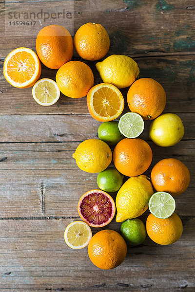 Geschnittene und ganze Zitronen  Orangen und Limetten auf Holz