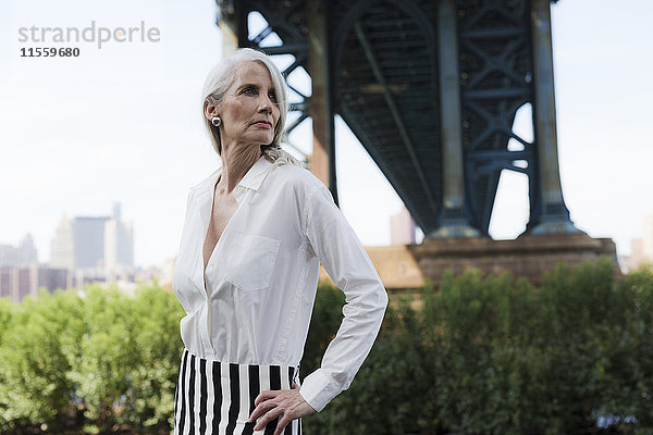 USA  Brooklyn  Dumbo  reife Frau vor der Manhattan Bridge stehend