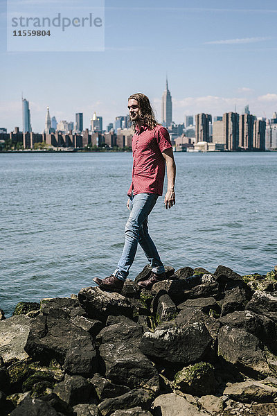 USA  New York City  Mann am Wasser mit Skyline von Manhattan im Hintergrund