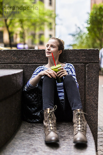 USA  New York City  Frau macht eine Pause und trinkt einen Smoothie in Manhattan.