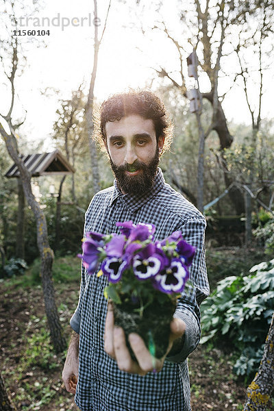 Mann mit einer Blume im Garten