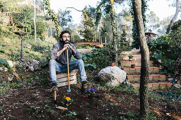 Der Mann im Garten macht eine Pause vom Gärtnern