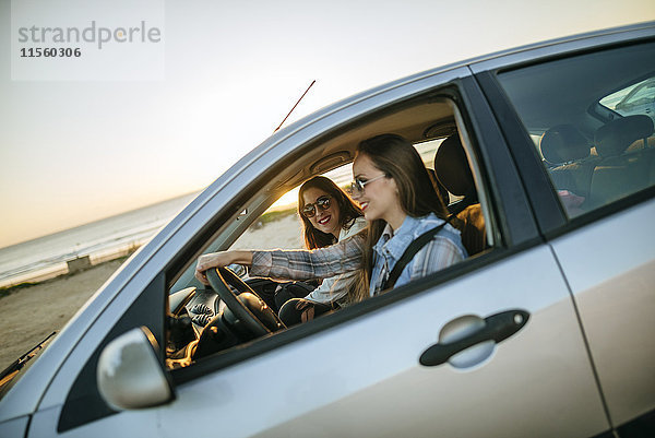 Zwei junge Frauen  die in einem Auto unterwegs sind.