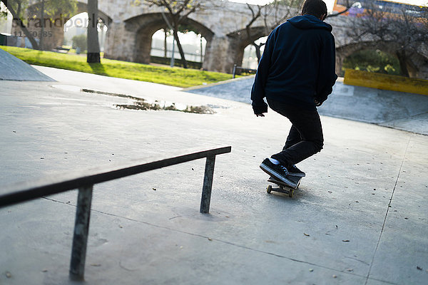 Junger Mann beim Skateboardfahren im Skatepark