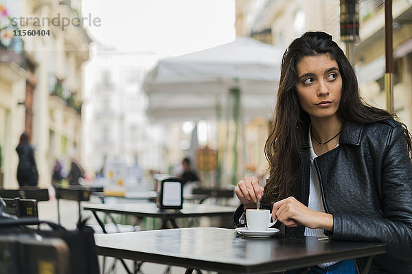 Junge Frau in einem Straßencafé