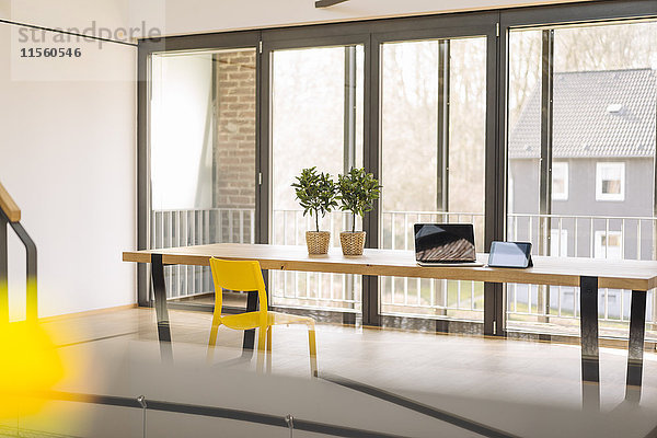 Leeres Loft-Büro mit Laptop  Tablette und Topfpflanzen auf dem Tisch