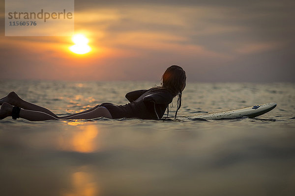 Indonesien  Bali  Surferin im Meer bei Sonnenuntergang