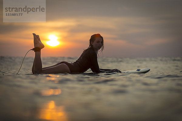 Indonesien  Bali  Surferin im Meer bei Sonnenuntergang