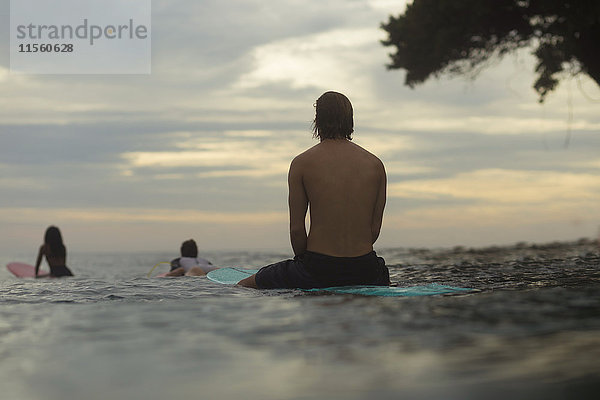 Indonesien  Java  Surfer auf dem Surfbrett auf dem Meer wartend auf eine Welle