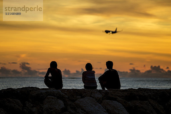 Indonesien  Bali  Menschen beobachten den Sonnenuntergang über dem Meer
