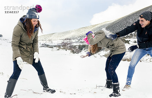 Freunde bei einer Schneeballschlacht im Schnee