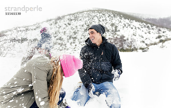 Freunde bei einer Schneeballschlacht im Schnee