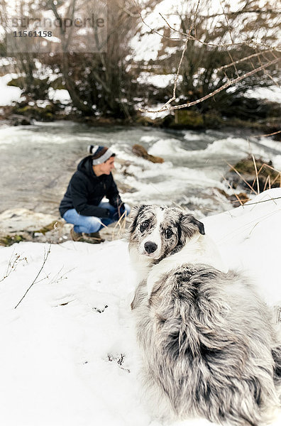 Junger Mann im Schnee mit seinem Hund