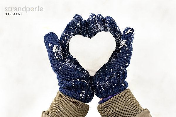Schneeherz an den Händen mit Handschuhen