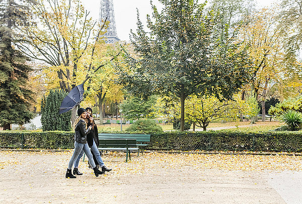 Frankreich  Paris  zwei junge Frauen im Park mit dem Eiffelturm im Hintergrund