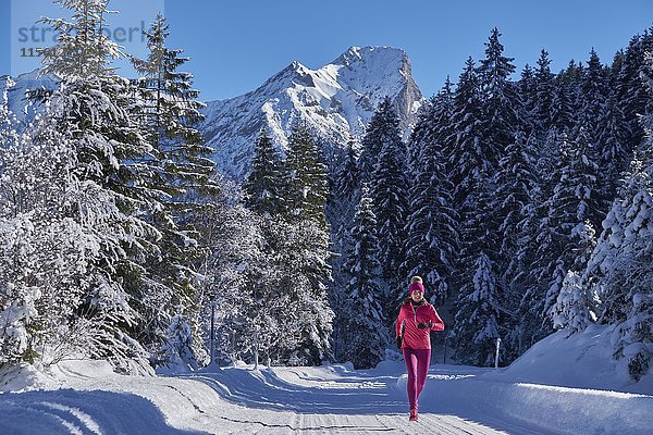 Österreich  Tirol  Karwendel  Riss-Tal  Frauenjogging im Winterwald