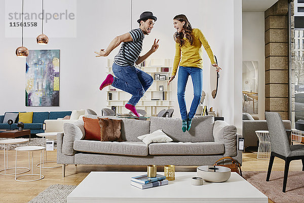 Paar im modernen Möbelhaus springen auf der Couch