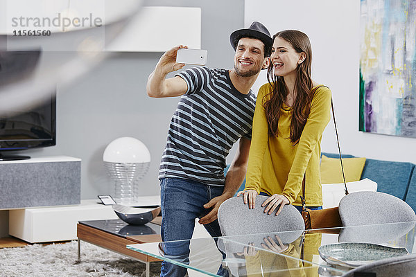 Paar im Möbelhaus mit Blick auf den Esstisch  Fotografieren mit Smartphone