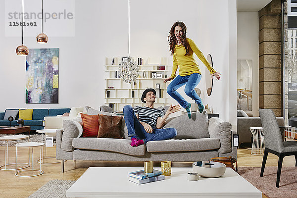 Paar im modernen Möbelhaus springen auf der Couch
