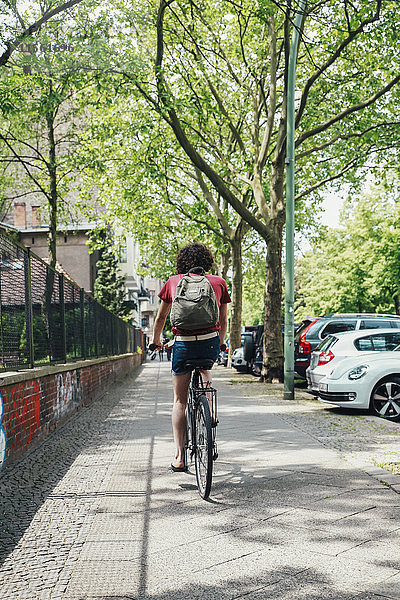 Junger Mann beim Radfahren auf dem Bürgersteig