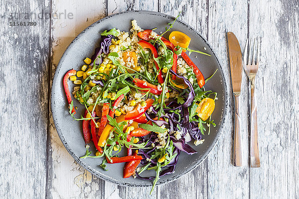 Glas Regenbogensalat mit Bulgur  Rucola und verschiedenen Gemüsen und Schalen mit Zutaten