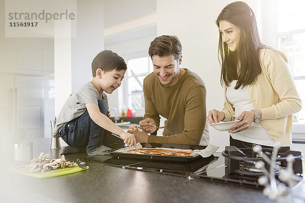 Familie bereitet gemeinsam Pizza in der Küche zu