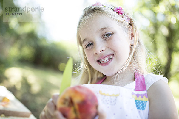 Porträt des lächelnden Mädchens im Freien mit Pfirsich